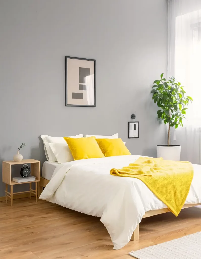grey bedroom walls with yellow cushions and decor accents