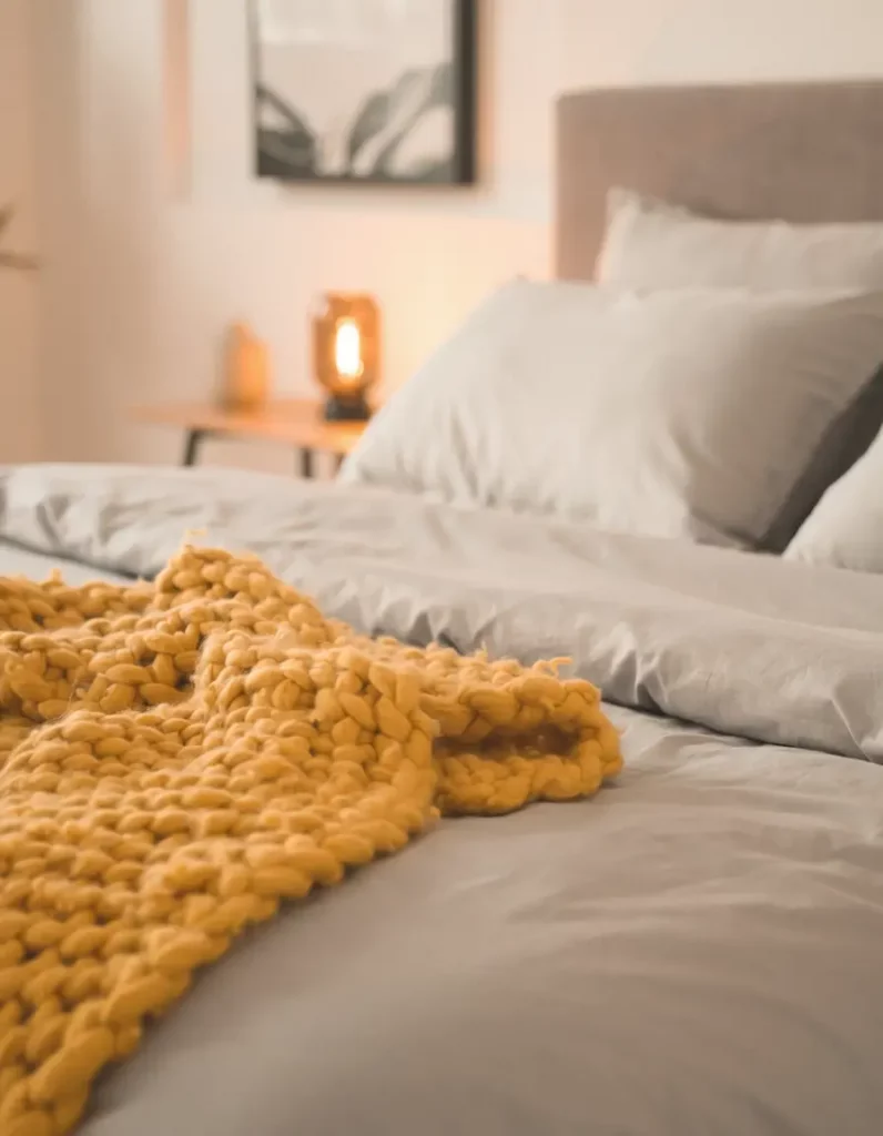 mustard yellow throw on grey bed for cozy bedroom look